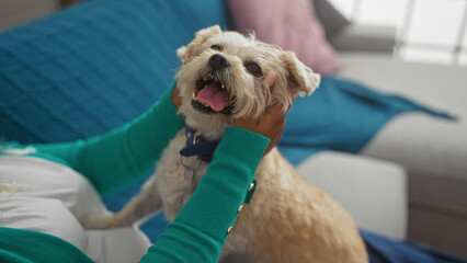 An african american woman lovingly pets her dog while relaxing in a cozy living room, capturing a moment of happiness and companionship in a home environment.