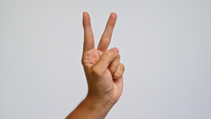 Man hand making victory gesture on plain white background showing peace sign