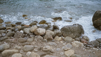 Rocky shoreline with crashing waves in a serene coastal outdoor setting, showcasing natural beauty and tranquility