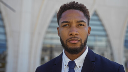 Handsome young african american man standing outdoors on a city street with an urban background in daylight