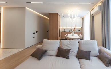 a living room with white walls and wood flooring in the center of the room, there is a glass sliding door that leads