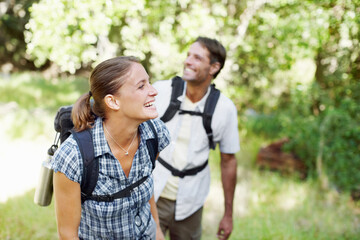 Couple, backpack and happy in nature for hiking, fitness and adventure with bonding, love and support. Man, woman and smile outdoor for exercise, health and trekking with journey, travel and walking