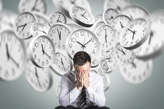 Stressed person overwhelmed by time pressure with clocks in background
