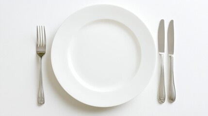 A minimalist dining setup featuring a white plate, fork, and knife.