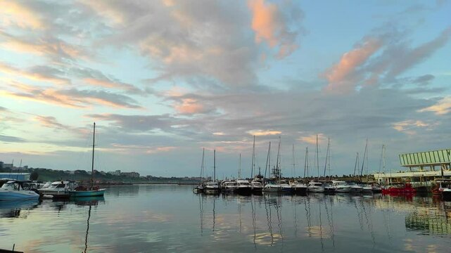 Moored boats in the small Tomis harbor and marina , near Constanta , a top travel destination on the Black Sea Coast , Romania , Eastern Europe , sunset scenery.