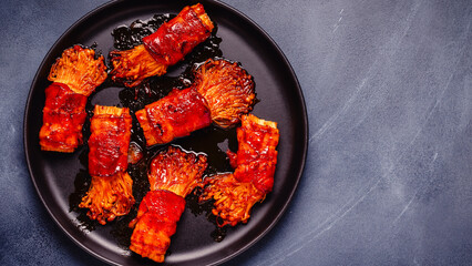 Bacon roll with enoki mushroom grilled with sauce.