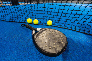 paddle tennis racket and balls on the blue paddle court