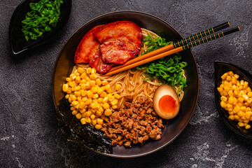 A bowl of ramen with noodles, meat and green onions.