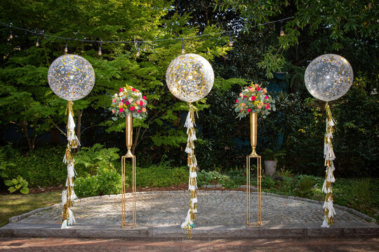 Elegant Outdoor Wedding Decoration with Balloons and Floral Arrangements in a Scenic Garden Setting
