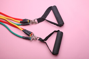 Rubber expander with handles for fitness on pink background