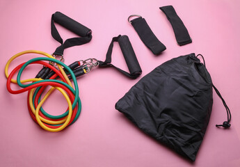 Rubber expander with handles for fitness on pink background