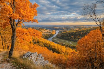 Fototapeta premium Autumn Serenity: A Breathtaking View of Vibrant Orange Foliage Overlooking a Meandering River and Rolling Hills Under a Dramatic Sky