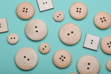 Wooden buttons on mint green background close up