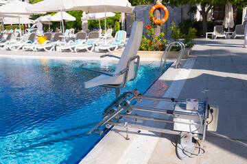 Disabled person pool lift. Swinging arm disabled chair. Swimming pool lift with a chair. Solution...