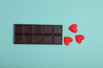 Dark chocolate bar with red hearts on a blue background