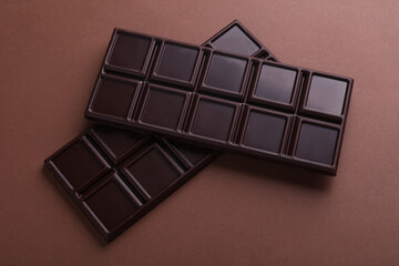 Dark chocolate bars on a brown background