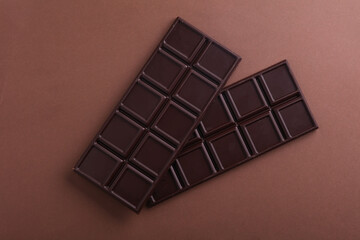 Dark chocolate bars on a brown background