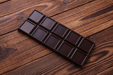 Dark chocolate bar on wooden background