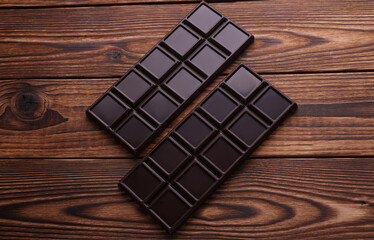 Dark chocolate bars on wooden background