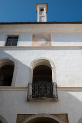 Paesaggio, fronte di casa d'epoca, antica con muri bianchi, porte e finestre.