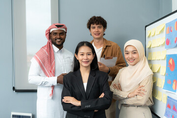 A diverse group of professionals standing confidently by a presentation board, representing teamwork and collaboration in a business setting.