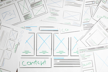 Developing UI design. Sketches of website wireframes on as background, top view