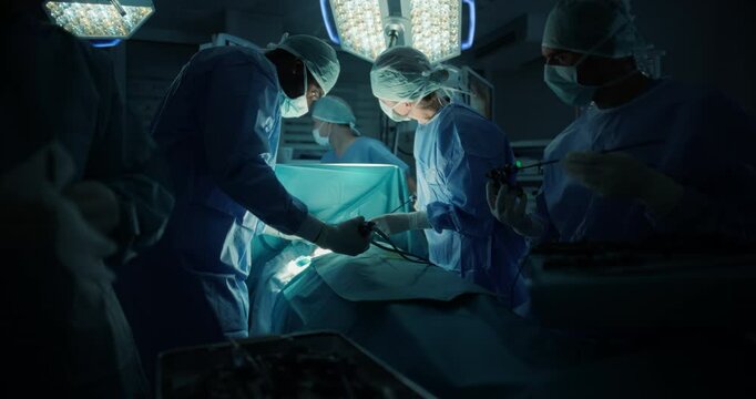 Professional Team of Male and Female Surgeons Conducting a Surgery in an Operating Theater in a Modern Hospital. Skilled Doctors Successfully Perform a Gastrointestinal Procedure