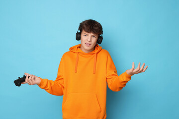 Teenage boy with controller on light blue background © New Africa