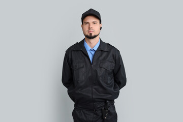 Security guard in uniform with earpiece on grey background