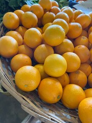 Basket of ripe oranges arranged neatly on a market stall, showcasing their juicy and fresh appeal