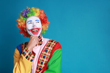 Portrait of happy clown on blue background, space for text © New Africa