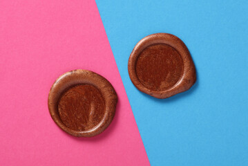 Brown wax seals on pink blue background