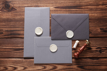 Envelopes with wax seals and vintage stamp on wooden background. Gift certificate, wedding...