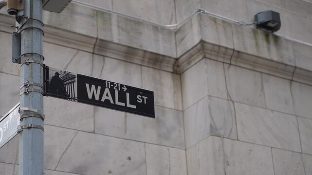 The iconic Wall Street sign stands as a prominent symbol representing global finance and investment industries