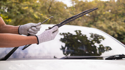mechanic is checking car wiper blades to replace new wiper blades for car during the rainy season...