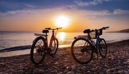 Obraz premium Two bicycles are parked on a sandy beach during sunset, their shadows stretching across the sand.