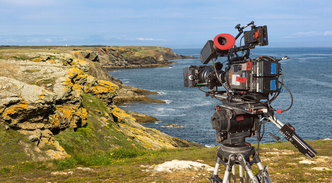 a film camera recording a scene by the ocean on a sunny day. Panoramic view with copy space. Documentary film production with movie camera in nature landscape