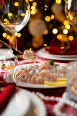 Festive fish table with Skagen salad - traditional Swedish starter dish with shrimps. Celebration delicacies on Christmas table in Finland and Scandinavia