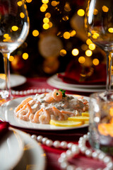 Festive fish table with Skagen salad - traditional Swedish starter dish with shrimps. Celebration delicacies on Christmas table in Finland and Scandinavia
