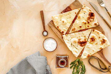 Italian focaccia with cheese and rosemary on beige background top-down copy space