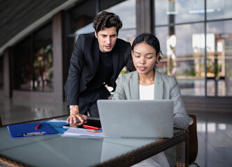 Latino man and African American businessperson brainstorming startup small business strategy together. Young multiracial businesswoman and colleague serious working on planning. Diversity people team.