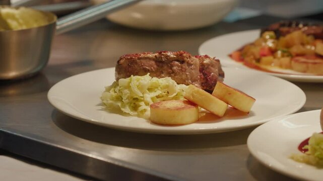 Chef elegantly plating gourmet dish with precision. Placing steak on the plate. Ideal for culinary tutorials or restaurant advertisements showcasing expert cooking techniques.