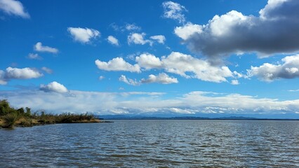 a beautiful blue lake, in the distance a small island overgrown with grass