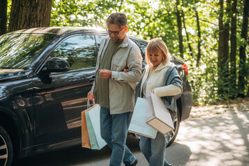 Car is parked, walking. Senior couple together outdoors at nature