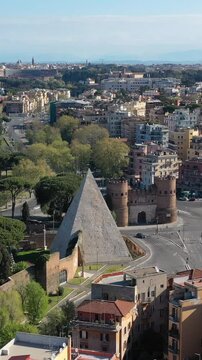 La Piramide Cestia e Porta San Paolo nel quartiere Ostiense di Roma. Italia. 
Ripresa aerea con drone del quartiere Ostiense di Roma.