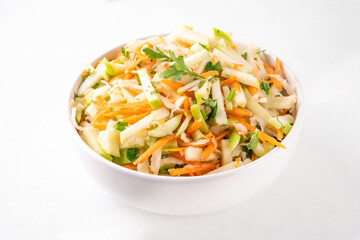 Homemade seasonal  Apple Slaw Salad with Apples, cabbage, carrot and spring onions. Healthy fall vegetable salad with yogurt dressing, in portioned bowls on kitchen table 