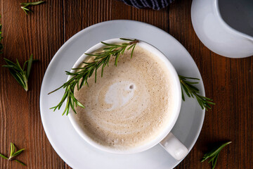 Cup of scented aromatic rosemary coffee latte, with whipped milk or cream