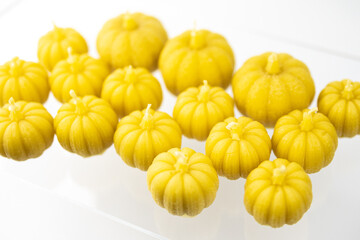 A group of beeswax Halloween yellow pumpkin candles isolated on white background
