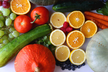 Various seasonal fruits and vegetables on white background. Summer and fall produce. Top view.