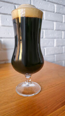 Glasses with light and dark beer on a dark background. Nuts and crackers